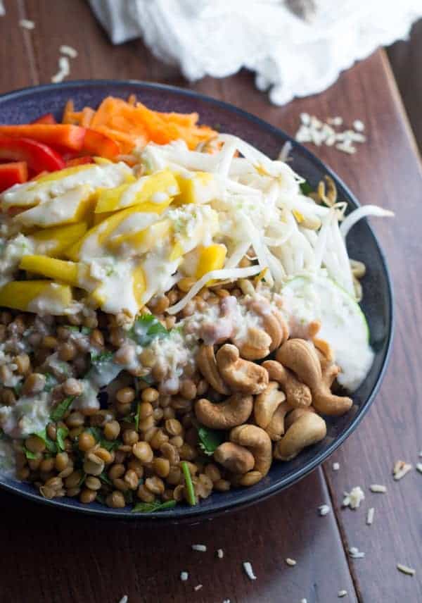 side angle view of bowl of tropical lentil salad with coconut lime dressing drizzled over top