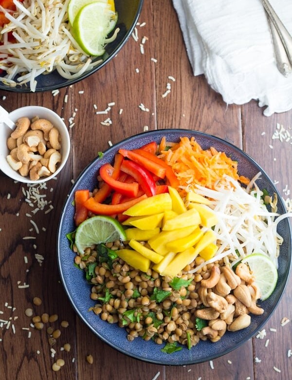 tropical lentil bowl with coconut lime dressing in navy blue bowl on wood table