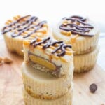stack of peanut butter cup cheesecakes with a pretzel crust on wood board