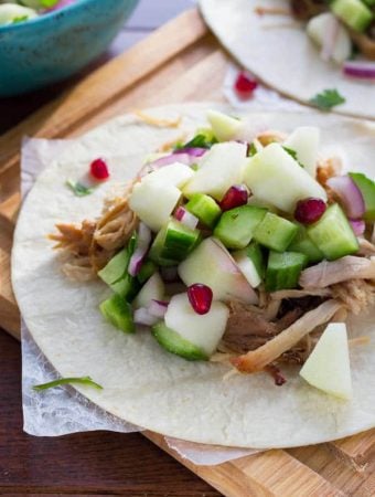 close up of of apple cider carnitas with fresh apple salsa on tortillas