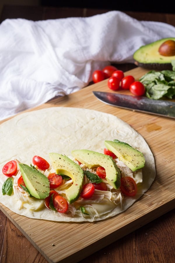 tortilla loaded with cheese, chicken, tomatoes, basil and avocado