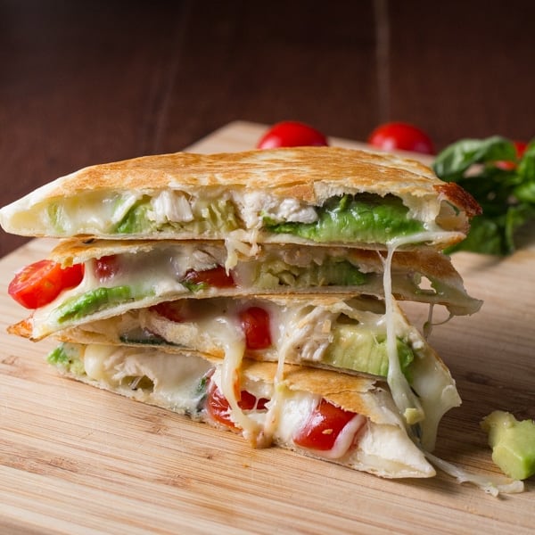 stack of cooked avocado caprese chicken quesadillas with melted cheese