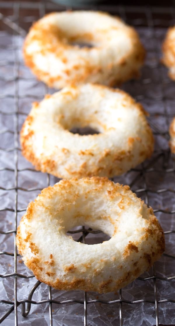 line of three angel food cake donuts on wire rack after baking