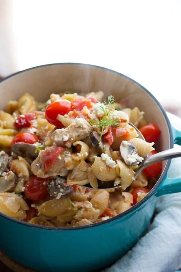 pasta with chicken feta and dill in large blue pot with spoon