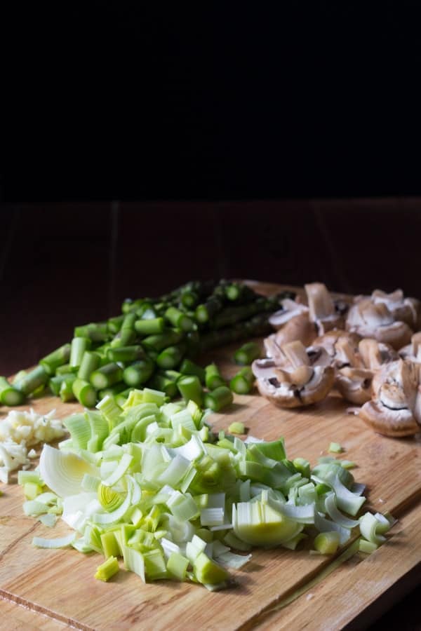 chopped leeks, mushrooms and asparagus on a cutting board