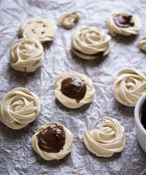 assembling the coffee meringue cookies with nutella on wax paper