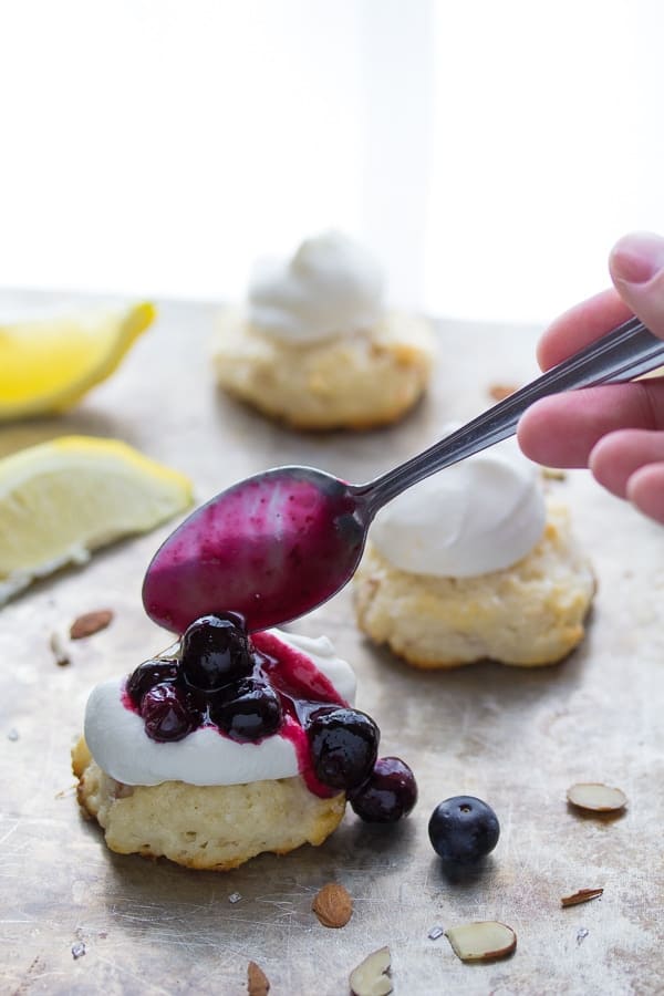 spooning the blueberry syrup over a blueberry almond shortcake 