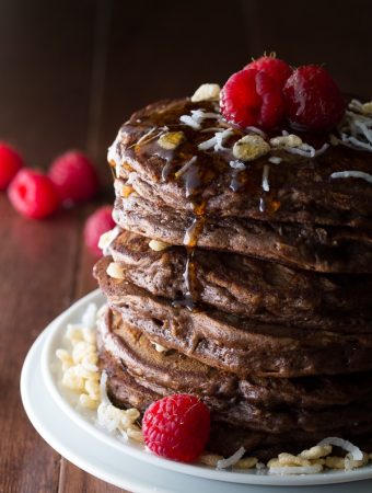 stack of coconut krispie chocolate pancakes with raspberries