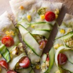 three slices of guacamole pizza with corn and zucchini