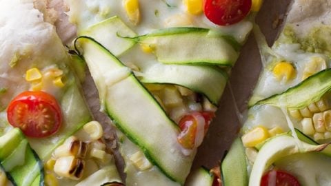 three slices of guacamole pizza with corn and zucchini