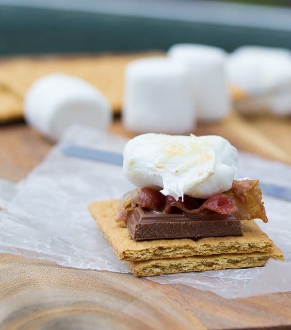 assembling the s'mores with chocolate, bacon and marshmallow