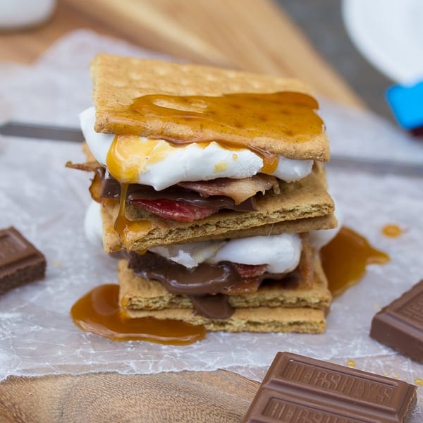 stack of caramel bacon s'mores with caramel sauce dripping down