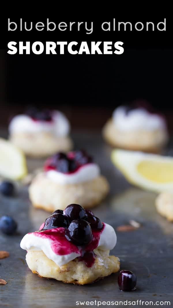 blueberry almond shortcake on a grey background with other shortcakes and lemon wedges in the background