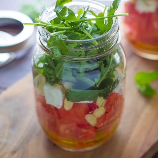 watermelon feta and arugula mason jar salad on wood board