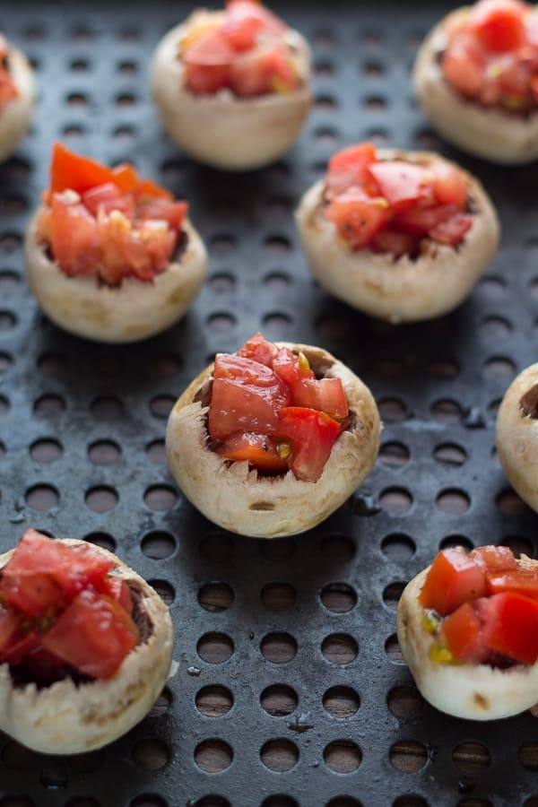 bruschetta stuffed mushrooms on vegetable grilling plate before grilling