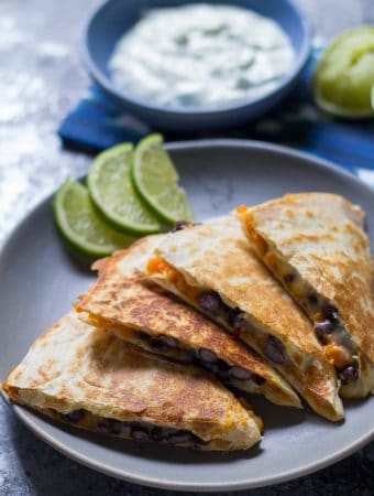 chipotle sweet potato black bean quesadillas on gray plate with lime slices