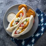two sweet potato falafel pitas on gray plate with dipping sauce