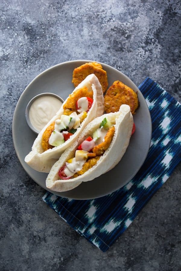 two sweet potato falafel pitas on gray plate with dipping sauce