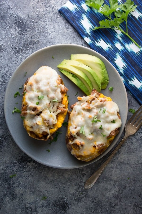 overhead view of two sausage stuffed sweet potatoes on grey plate