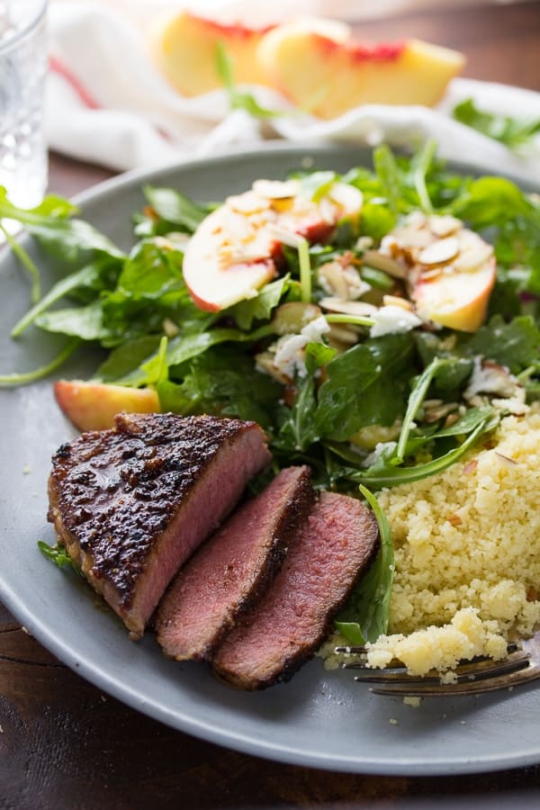 brown sugar chili lamb chops sliced open on plate with salad and couscous