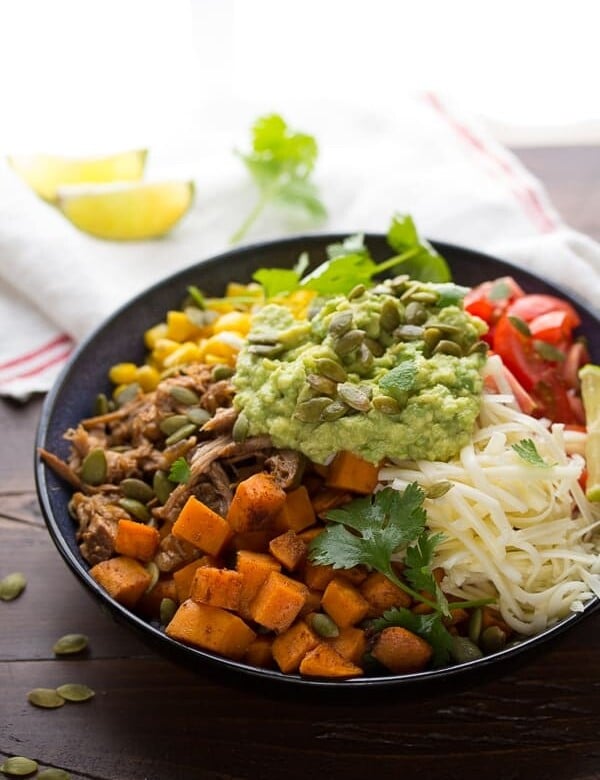 fall burrito bowl with maple pork sweet potatoes and pepitas in black bowl