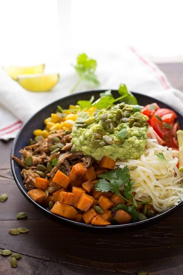fall burrito bowl with maple pork sweet potatoes and pepitas in black bowl