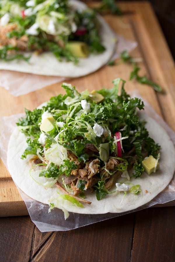 side angle view of two maple pork tacos on a cutting board