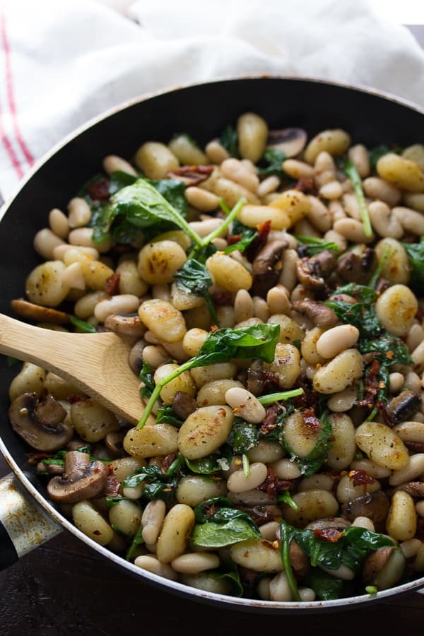 Gnocchi With Sundried Tomatoes, spinach, mushrooms and White Beans in large skillet