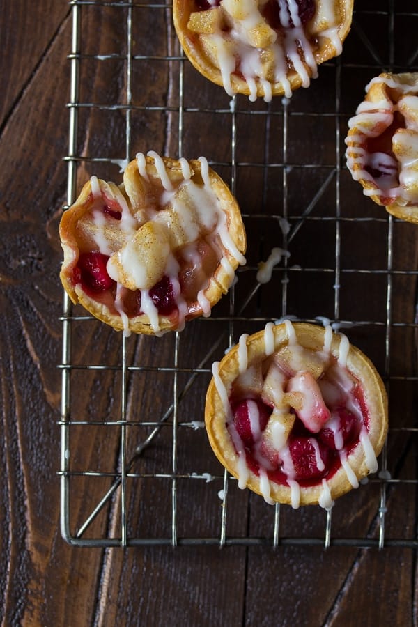 overhead view of mini pear and cranberry pies with brown butter glaze on wire rack