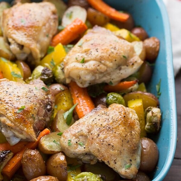 close up shot of roasted chicken and fall vegetables with miso honey butter in blue bowl