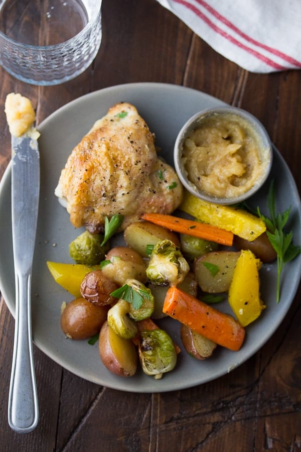 roasted chicken and vegetables on grey plate with bowl of honey miso butter