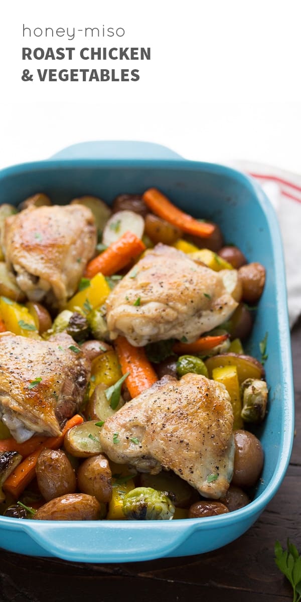 blue baking dish with roasted vegetables and roasted chicken thighs