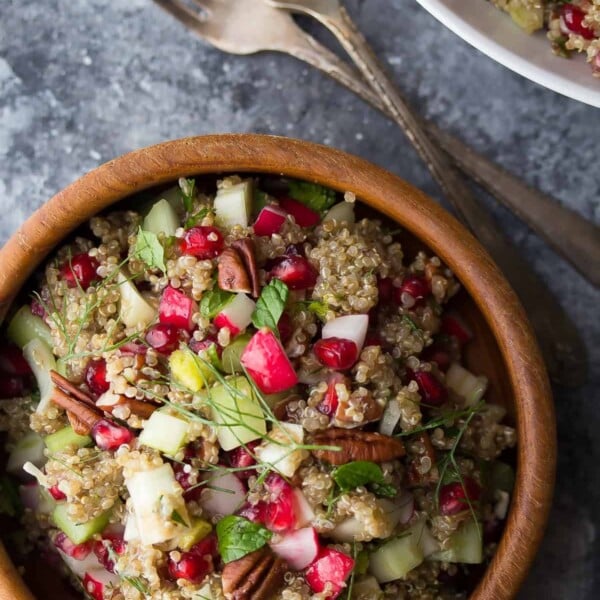 overhead shot of pomegranate fennel quinoa salad in wood bowl with forks