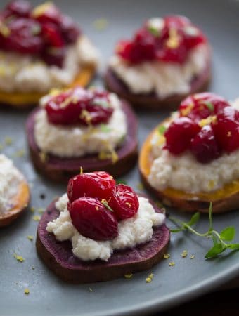 three sweet potato ricotta and cranberry rostinis on gray plate