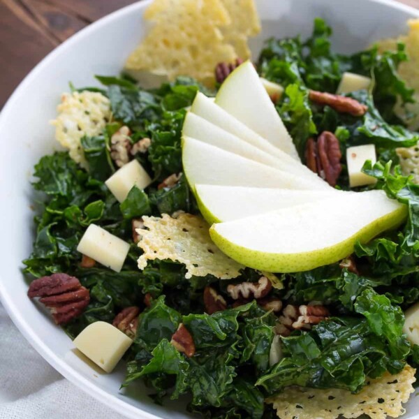 white bowl filled with balsamic winter kale salad and havarti crisps