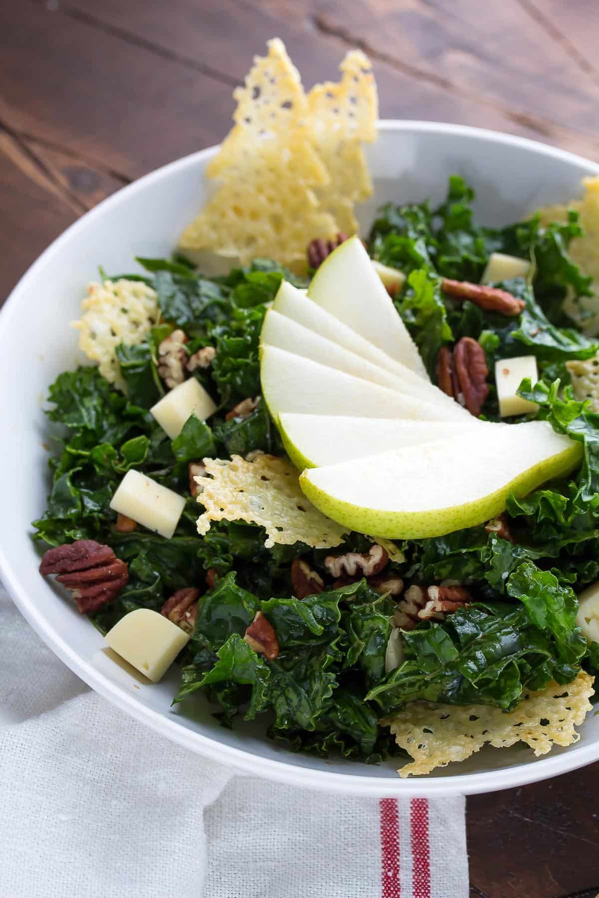 side angle view of winter balsamic kale salad with havarti crisps