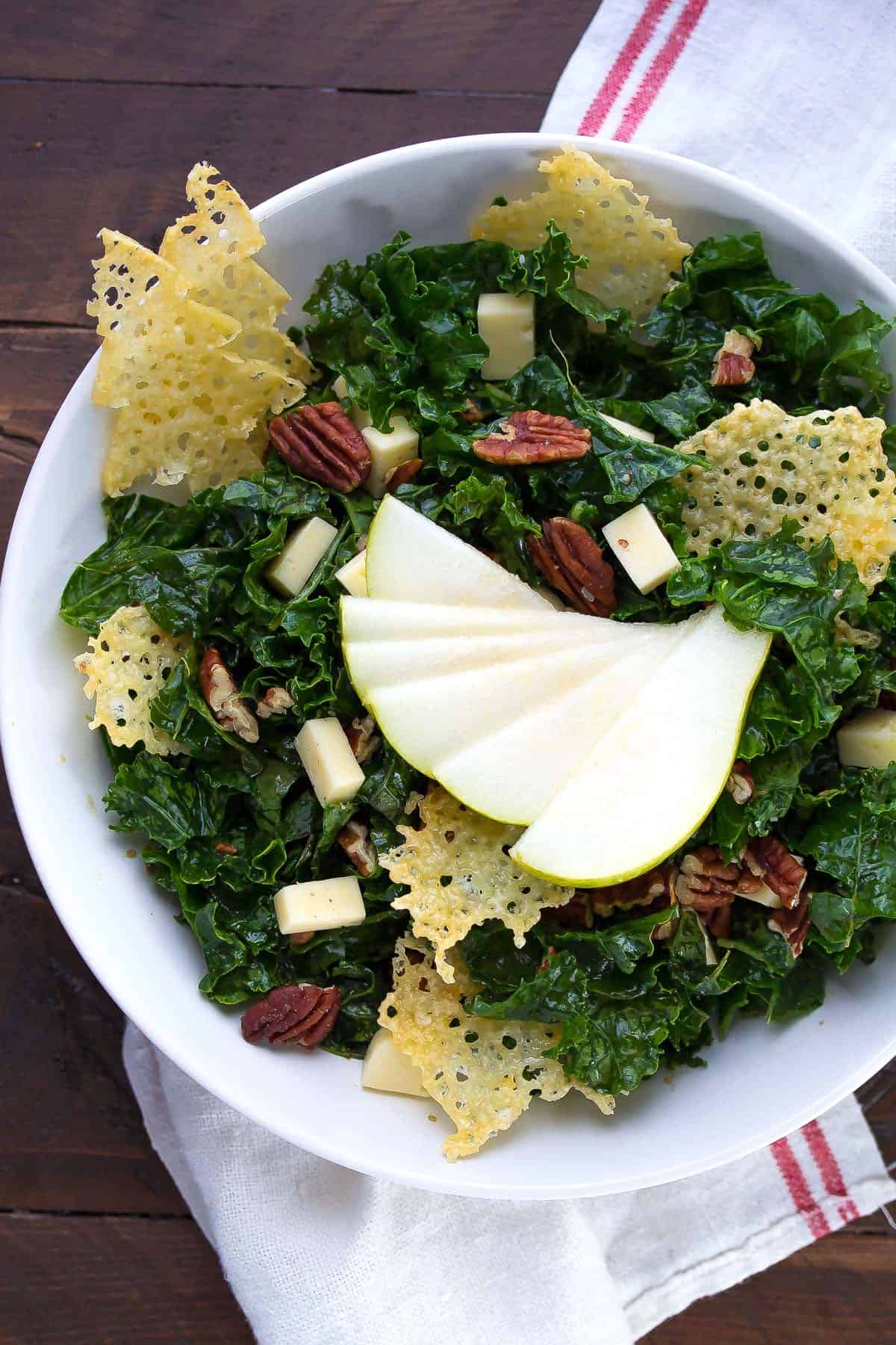 overhead view of balsamic winter salad in white bowl with pear slices fanned out on top