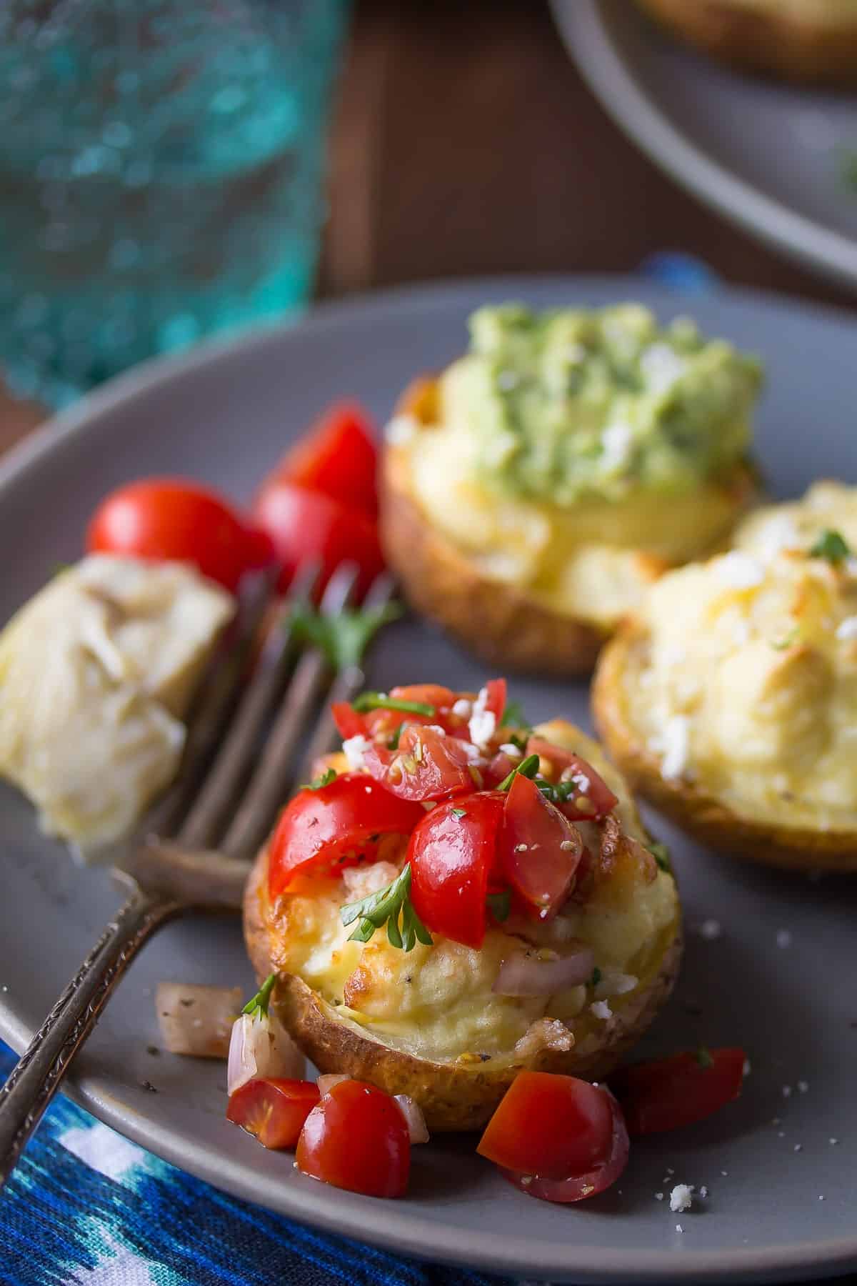 twice baked breakfast potatoes on a plate, topped with cherry tomato bruschetta