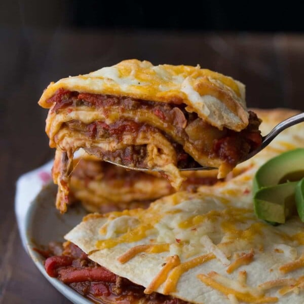 chili tortilla stacks on gray plate with avocado slices