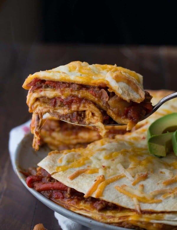 chili tortilla stacks on gray plate with avocado slices