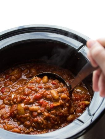 hand stirring roasted red pepper chili in the crock pot