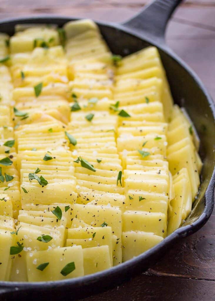 unbaked domino potatoes in a cast iron skillet