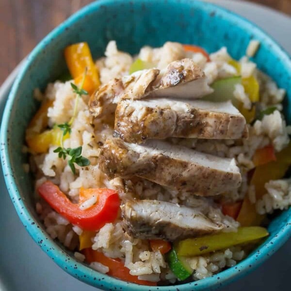 overhead shot of jerk chicken coconut rice with vegetables in blue bowl