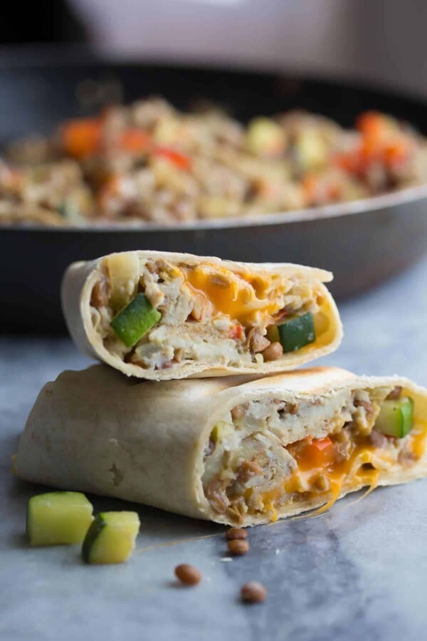 stack of two zucchini lentil breakfast burritos on gray counter
