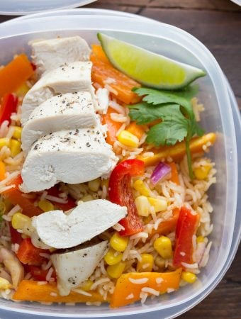 Close up shot of a meal prep container with chicken fajita lunch bowls and lime wedge