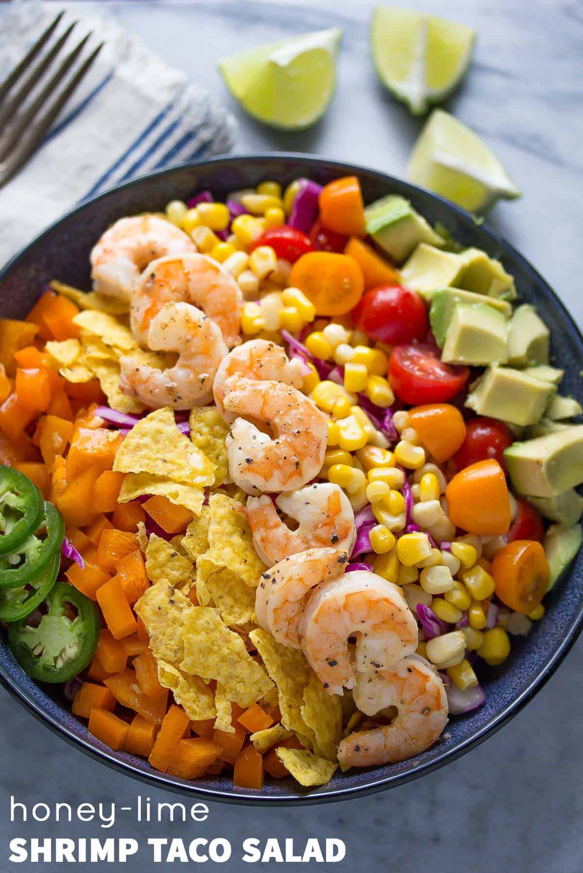 A light and fresh shrimp taco salad recipe that is packed full of veggies and tossed in a honey-lime vinaigrette. Ready in 20 minutes!