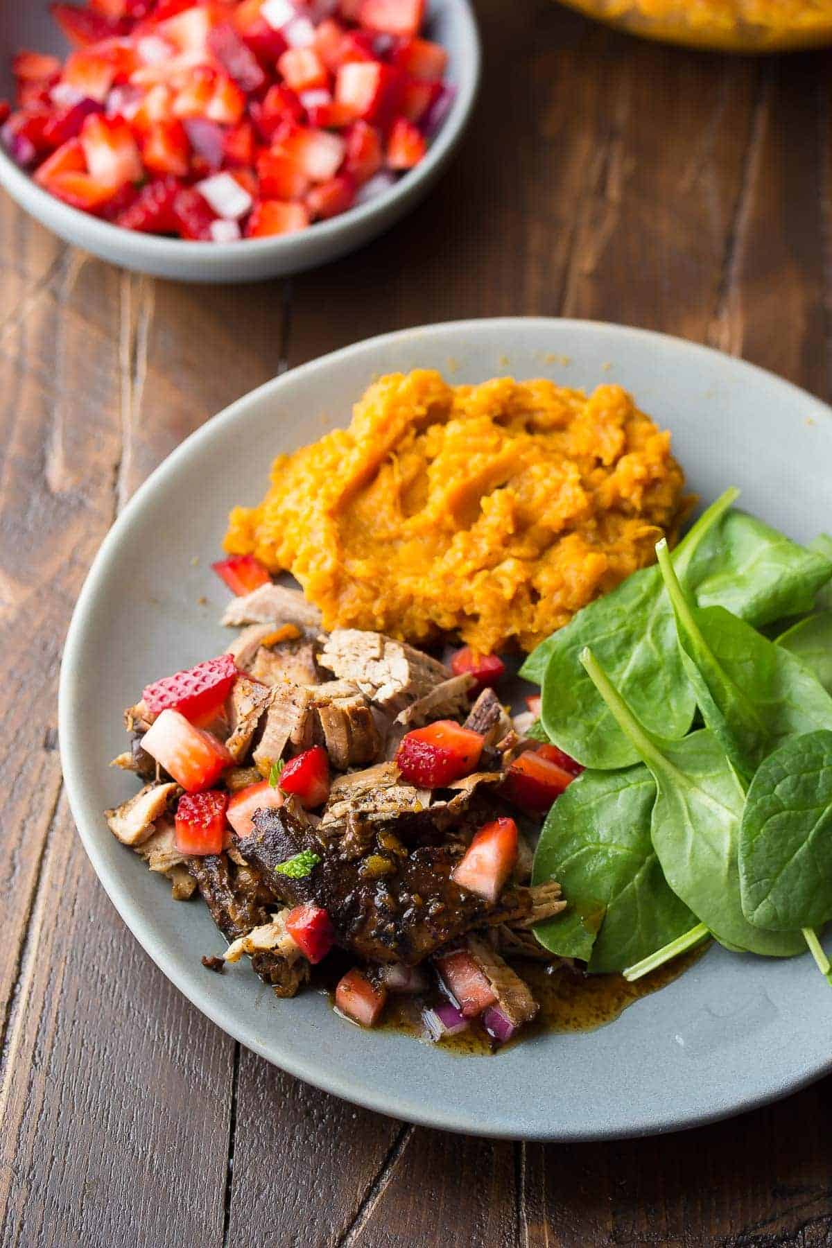 This slow cooker pork tenderloin is cooked in a tangy balsamic sauce with sweet potatoes, then topped with a fresh strawberry salsa
