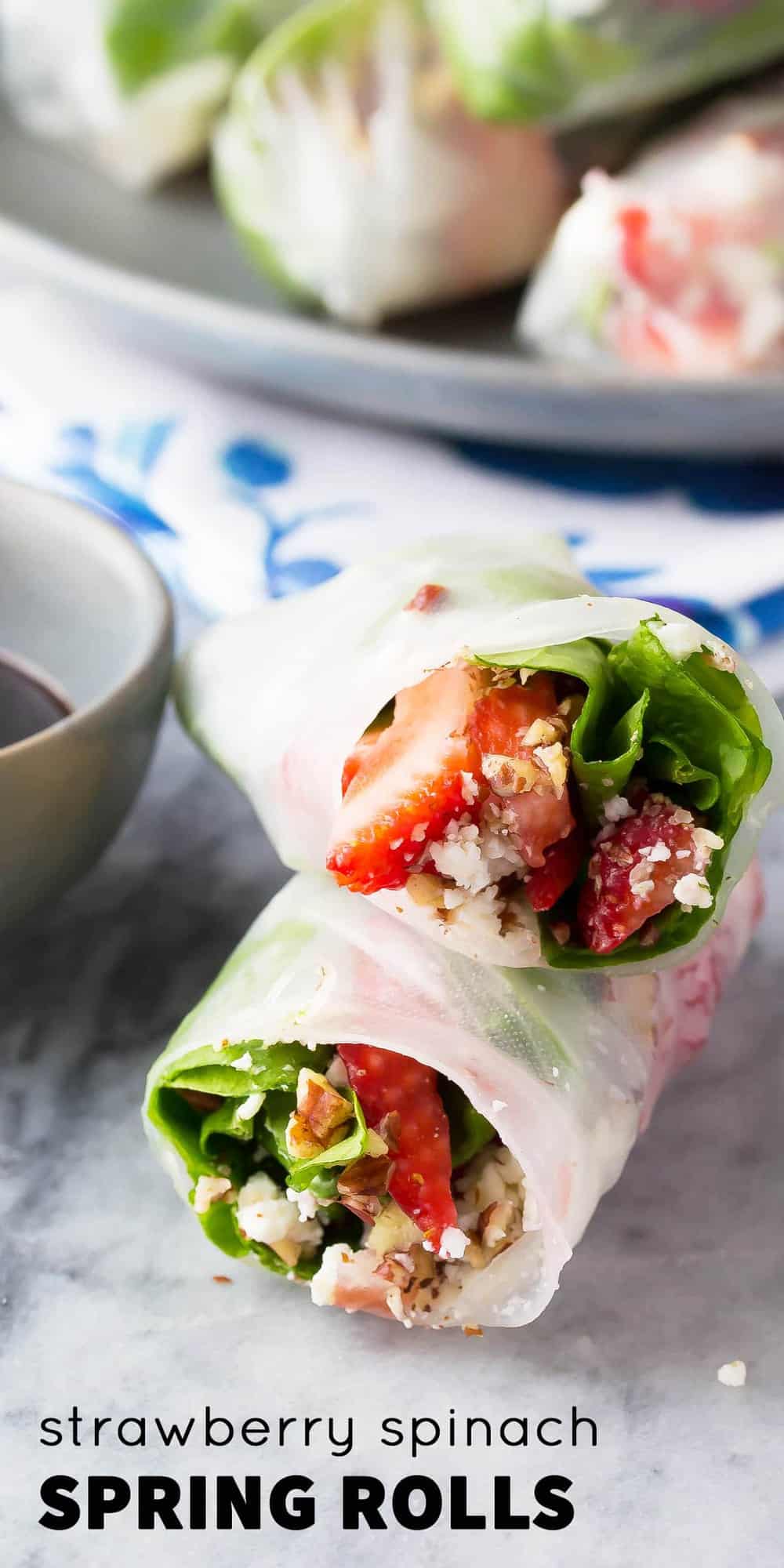 two strawberry spinach spring rolls stacked on each other showing the filling