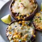 enchilada stuffed grilled portobello mushrooms on gray plate with lime