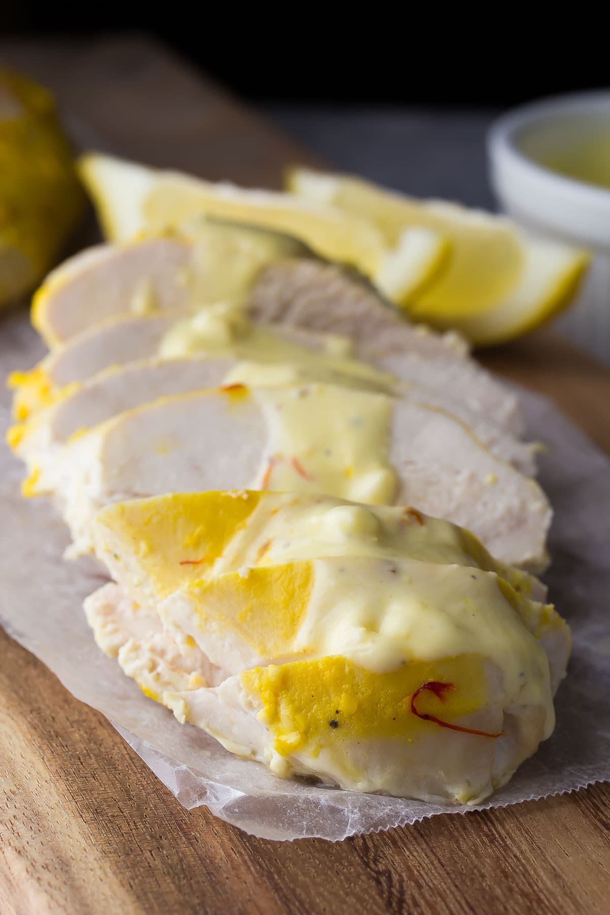 sliced greek yogurt chicken with saffron sauce spooned over top